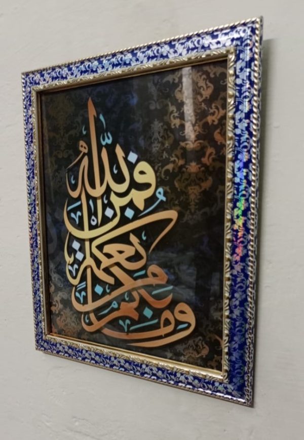 Decorative wall art with Arabic calligraphy in a blue and gold frame.
